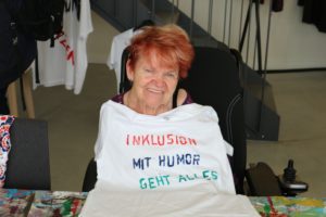 Eine Teilnehmerin. Auf ihrem T-Shirt steht: Inklusion - Mit Humor geht alles.