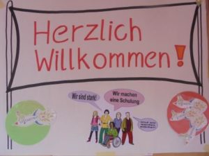 Poster mit dem Schriftzug "Herzlich willkommen"