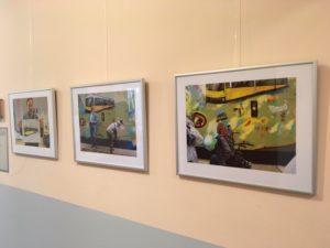 Drei Bilder der Fotoausstellung hängen an einer Wand.