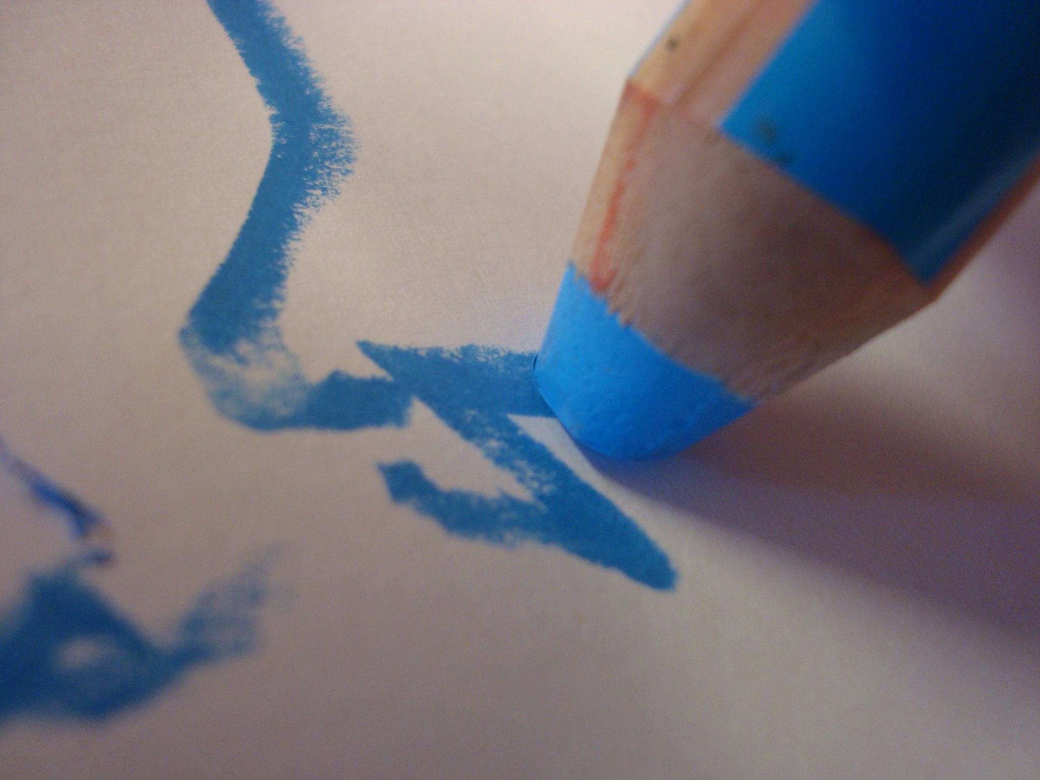 Blauer Stift malt auf weißm Papier